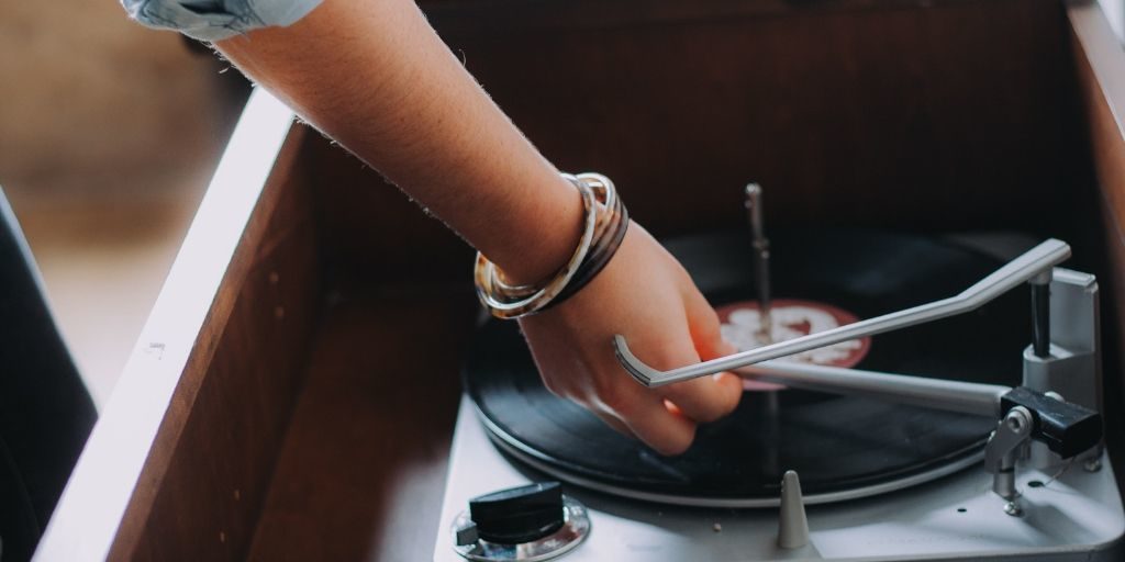 Woman reaching down and putting on a record