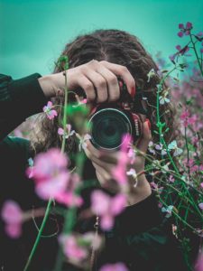 Photographer behind the camera in a field of flowers