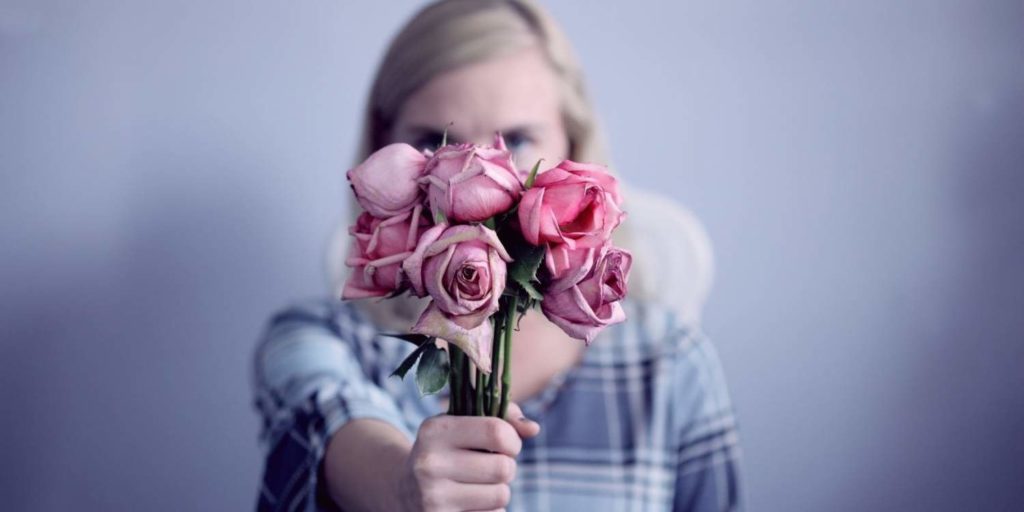 woman holding a bunch of pink roses