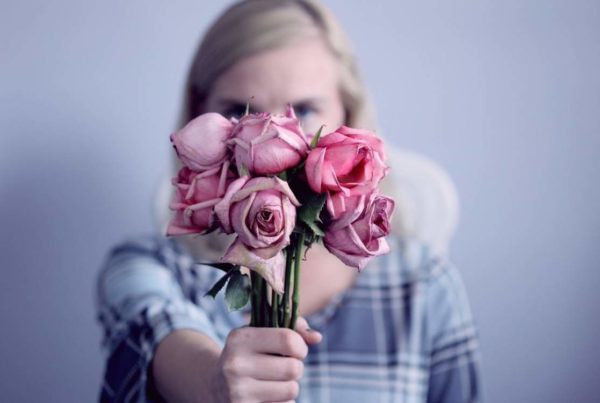 woman holding a bunch of pink roses