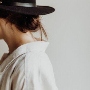 Woman in brown hat and white shirt , photo taken from behindindicating an energetic shift